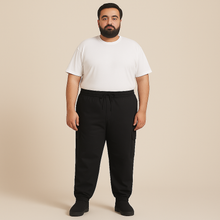Plus-size male model wearing black twill cotton cargo joggers with side and back pockets