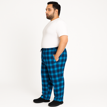 Blue plaid plus-size jersey lycra trousers with drawstring waistband, laid flat on white background