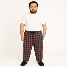 Red and grey plaid plus size lounge trousers with black drawstring, laid flat on a white background